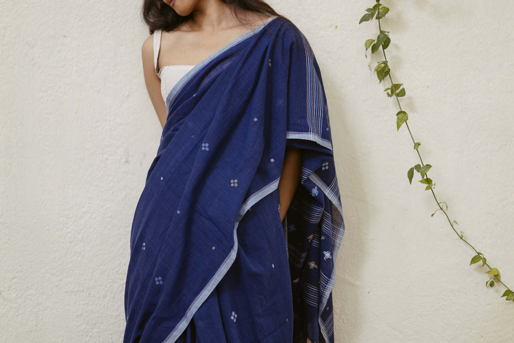Woman wearing a natural indigo khadi cotton saree with white jamdani motifs