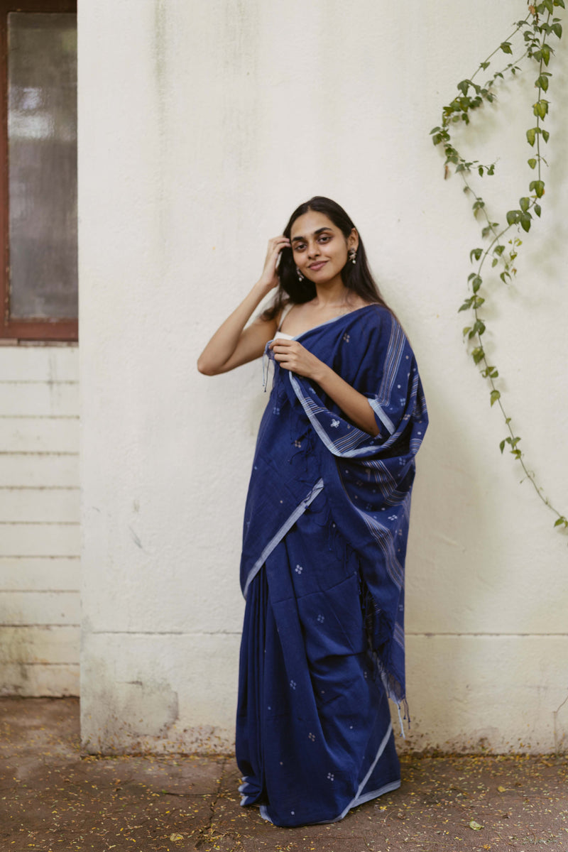 Woman wearing an natural indigo saree with jamdani motifs arrangement on the pallu 