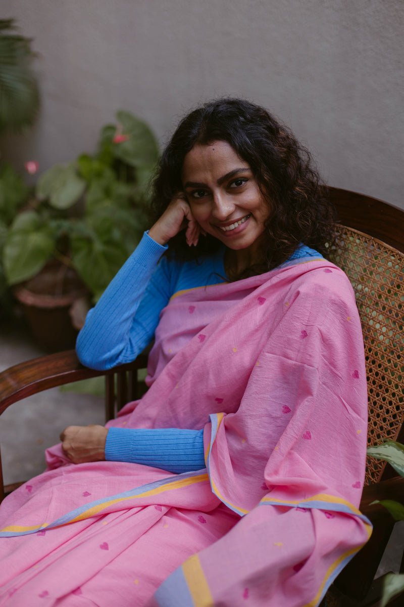 Handwoven pink cotton saree with heart-shaped motifs and colorful border