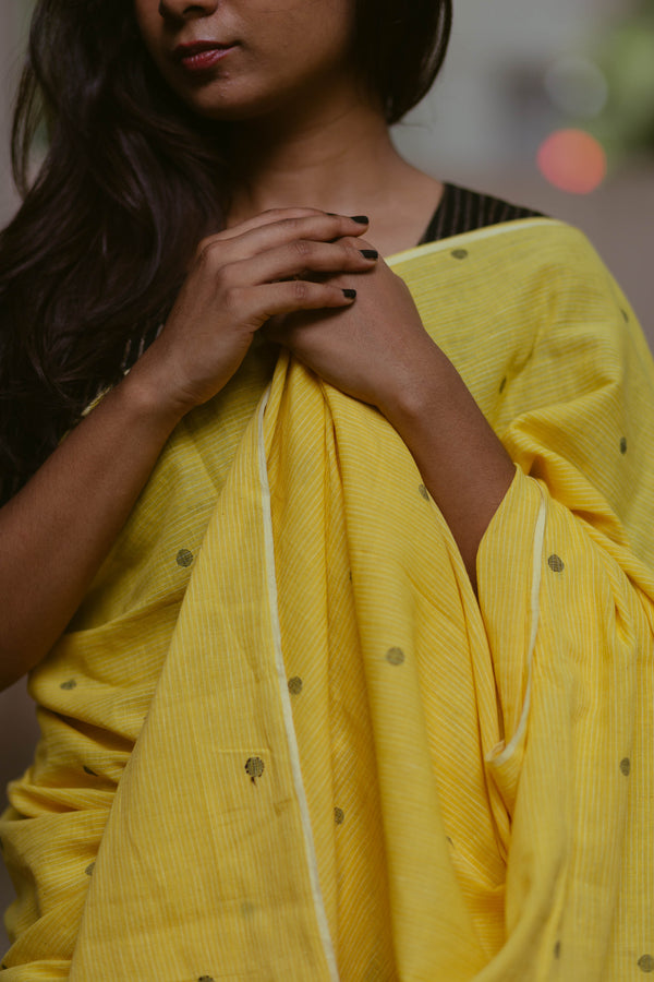 Elegant yellow Khadi Jamdani saree with black polka dots, handwoven Indian traditional wear for women