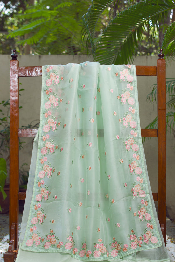 Elegant Light Green Silk Organza Saree with Rose Floral Design – Featuring delicate pink rose floral embroidery along the border of a green silk organza saree.