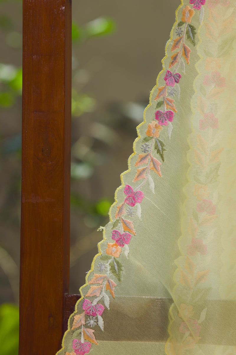 Hand-embroidered silk organza saree in pastel yellow with colorful floral designs