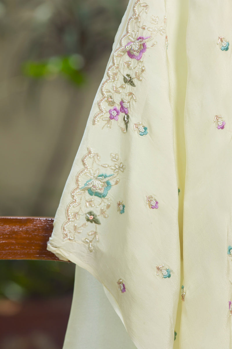 Elegant ivory organza saree drape with scattered floral butis and scallop border