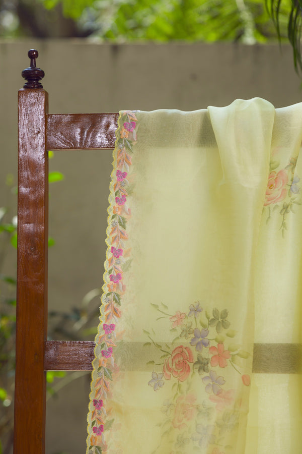 Pastel yellow silk organza saree with floral embroidery and scalloped border