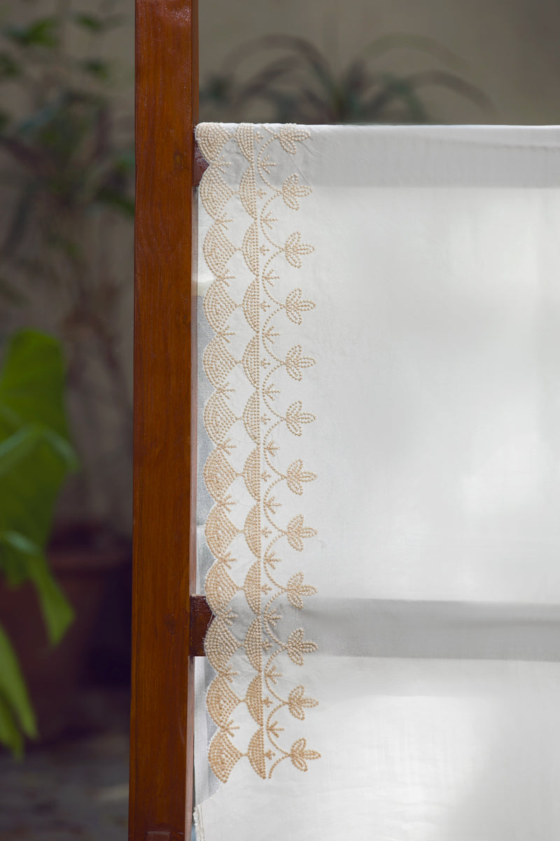 Snow Garden Silk Organza Saree with Elegant Beige Floral Patterns – A detailed close-up of delicate beige floral patterns embroidered on a pristine white silk organza saree.