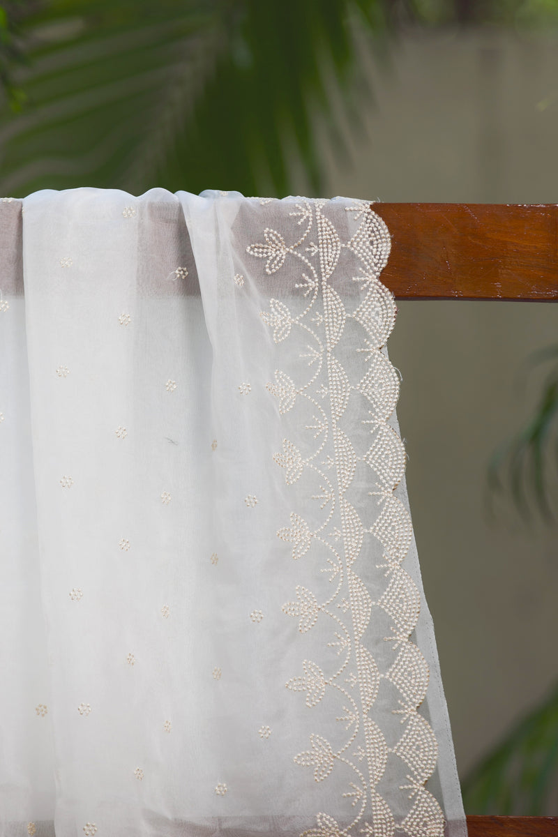 Snow Garden Silk Organza Saree with Scalloped Embroidered Edging – A detailed view highlighting the scalloped embroidered border and intricate floral patterns on a white silk organza saree.