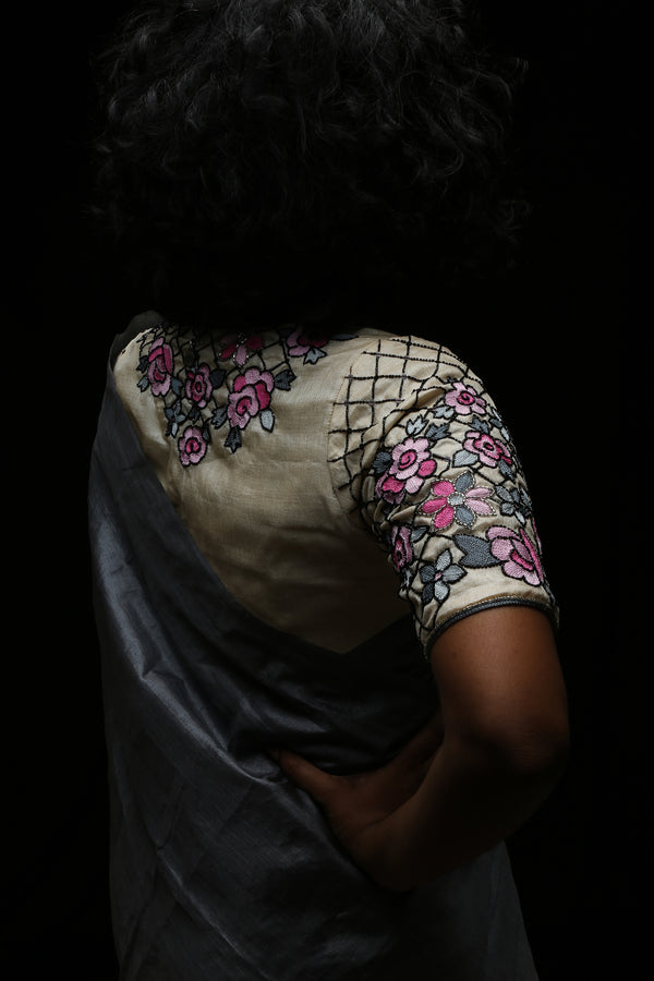 Back neckline of varsaaedit champagne-gold hand-embroidered saree blouse with pink roses, grey leaves and black beaded lattice.