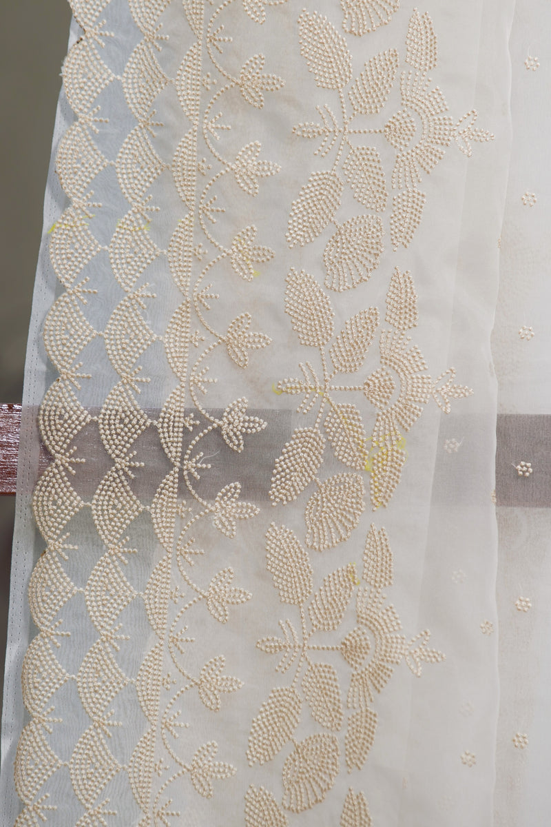 White Silk Organza Saree with Beige Floral Embroidery Design – Close-up shot showing intricate beige floral and leaf motifs on a snow white silk organza saree.